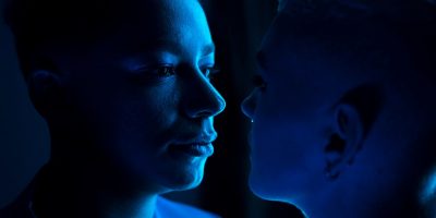 A striking portrait of a person with a blue light background, highlighting their features and expressions.
